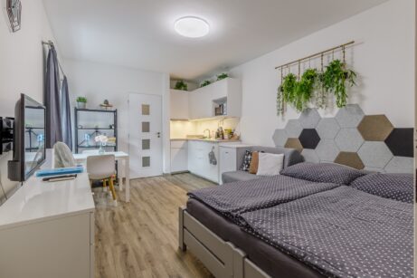 Celkový pohled na&nbsp;obytnou část apartmánu s&nbsp;postelí a&nbsp;kuchyní – Neratovice, Masarykova 69/2